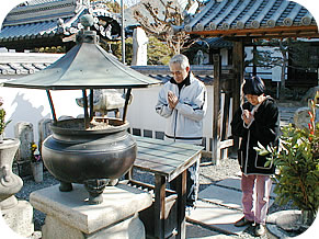 墓参りする久山さんと寺田薬局寺田さん